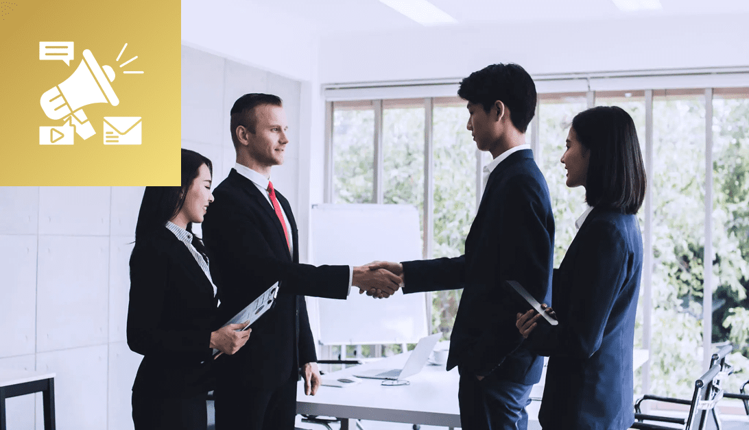 Business professionals shaking hands in a modern office setting.