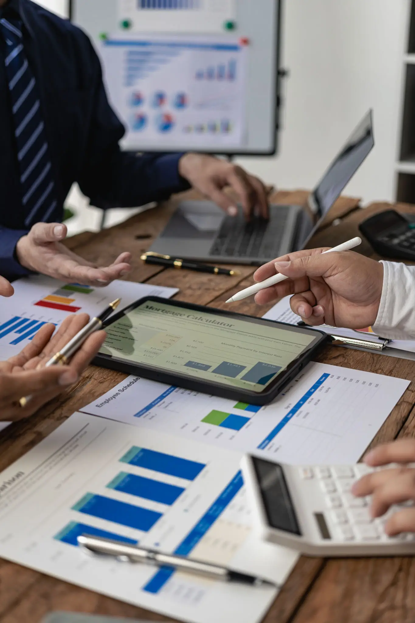 Business meeting with digital devices and charts on the table.